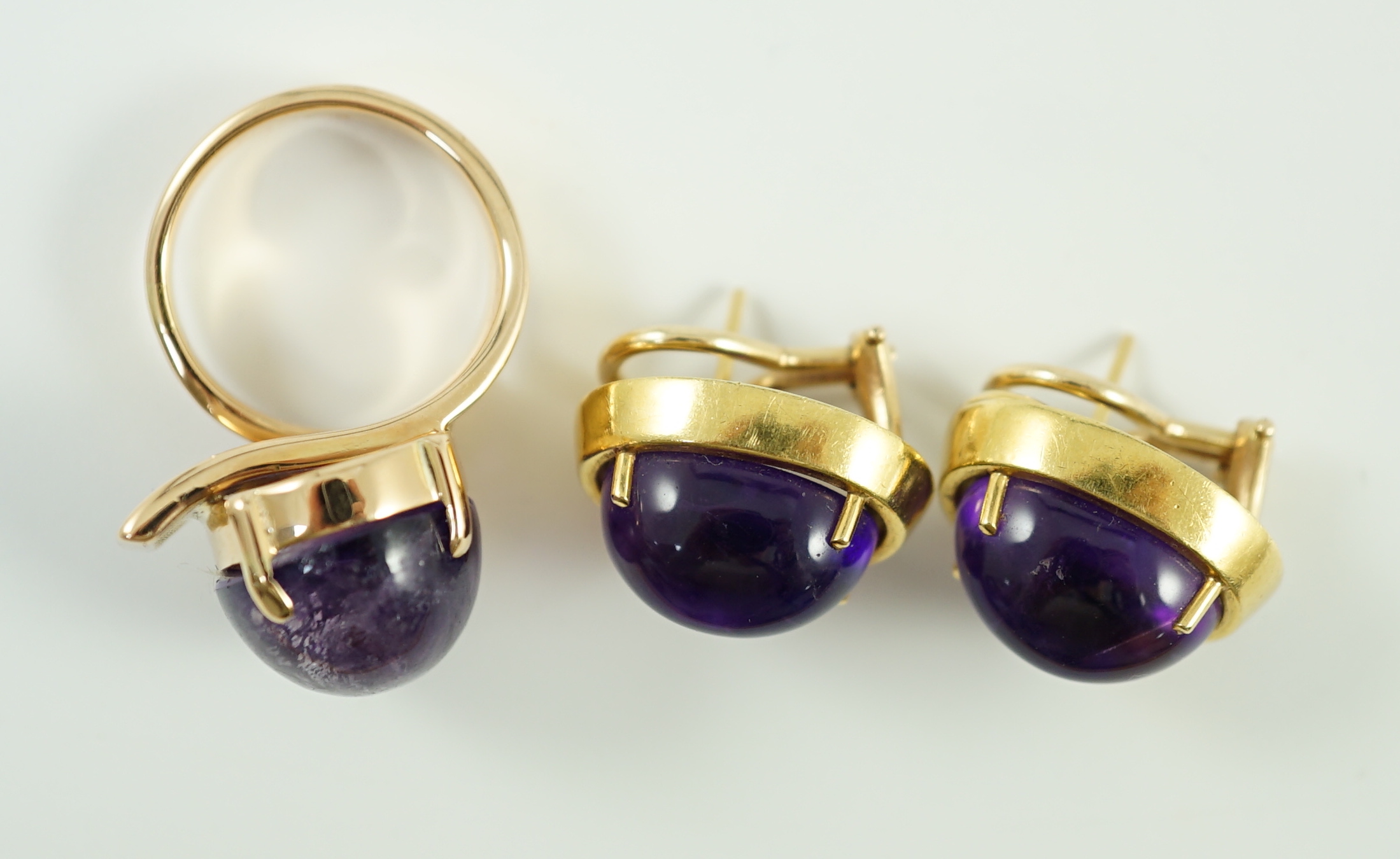 A modern gold and cabochon oval amethyst set dress ring and a pair of similar earrings